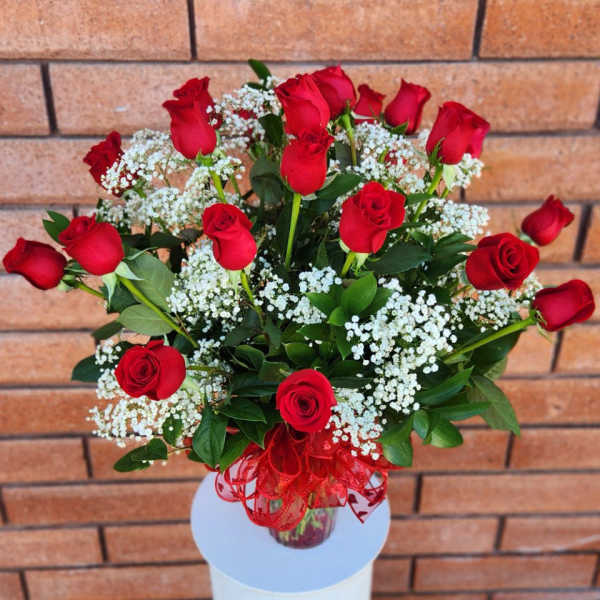 Bouquet of red roses with white baby's breath in a glass vase