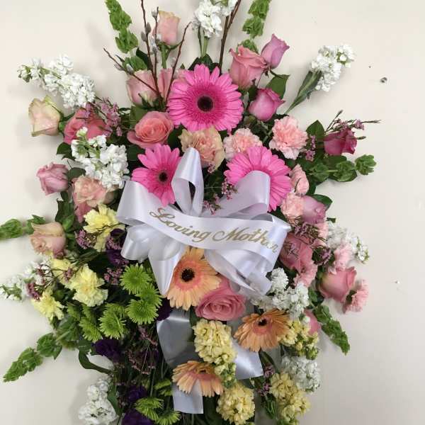 Heart-shaped floral wreath with pink and white flowers and a ribbon