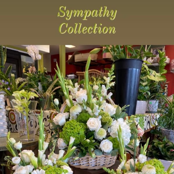 Sympathy floral arrangements with white roses and green blooms in vases and baskets