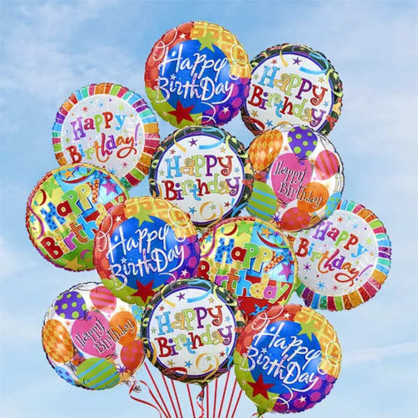 Cluster of colorful birthday balloons against a blue sky
