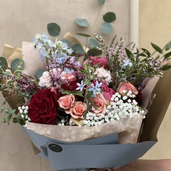 Mixed bouquet of red and pink roses with small white filler flowers