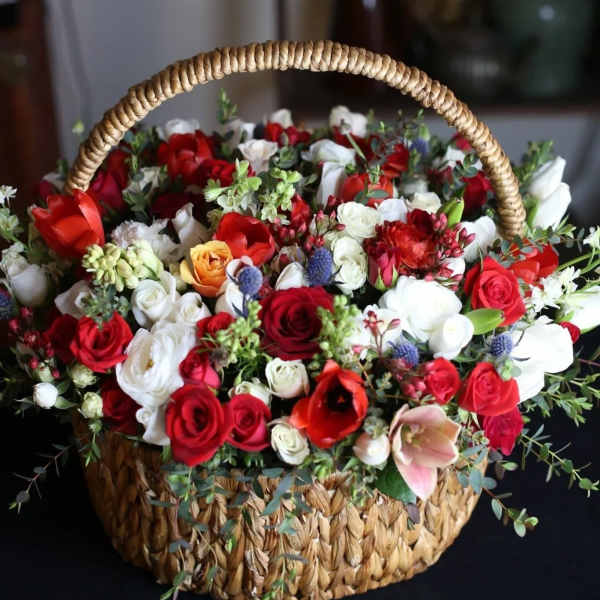 Basket of red and white roses with mixed blooms and greenery