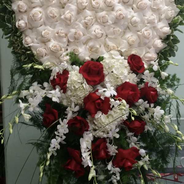 Heart-shaped white rose arrangement with red roses and white orchids below