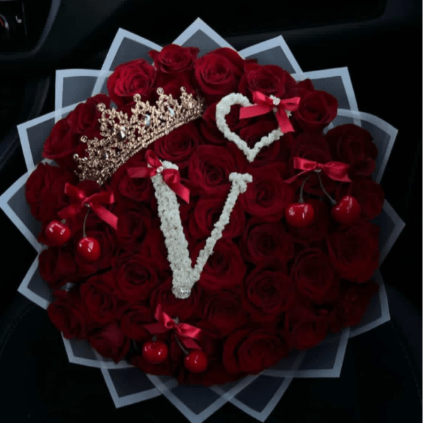 Heart-shaped bouquet of red roses with decorative crowns and cherries