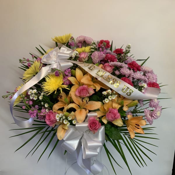 Colorful mixed flower arrangement with ribbons and a white bow