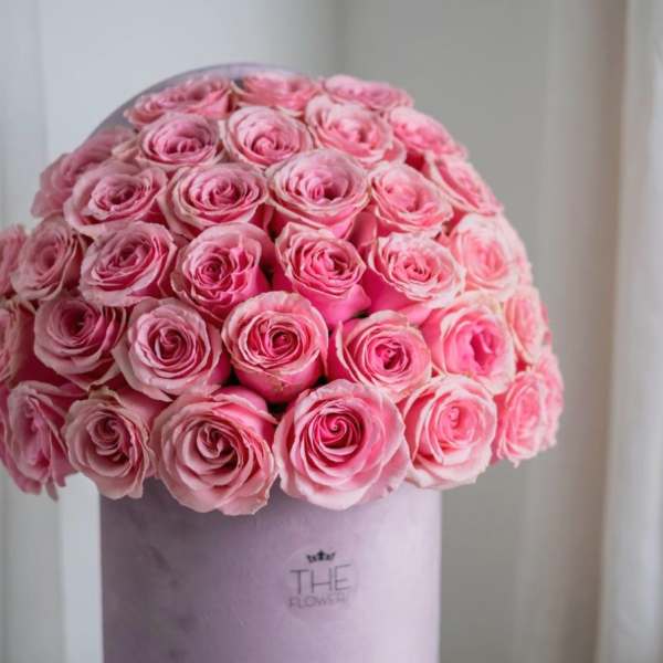 Round bouquet of pink roses in a lavender hatbox