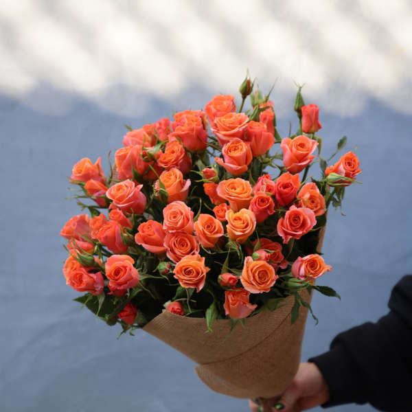 Bouquet of orange roses wrapped in burlap