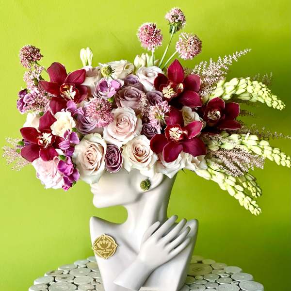 Floral arrangement in a white bust vase with pink and burgundy blooms