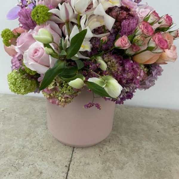 Pink and white mixed flower arrangement in a pale pink vase