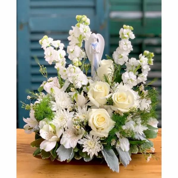 White floral arrangement with roses and tall blossoms in a low container