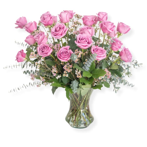Pink roses in a clear glass vase with small filler flowers