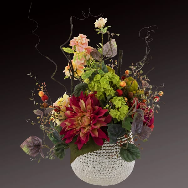 Mixed floral arrangement in a textured white vase with tall curly branches