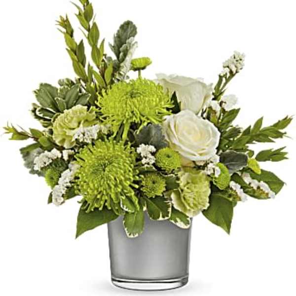 Green and white floral arrangement in a clear glass vase