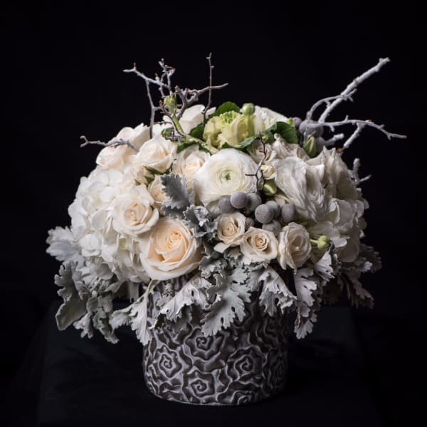 White roses and hydrangeas in a textured gray vase