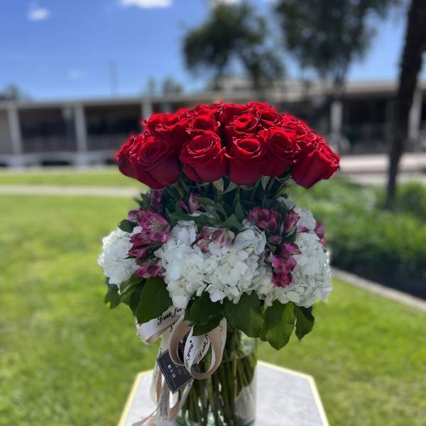 Red roses and white hydrangeas in a glass vase
