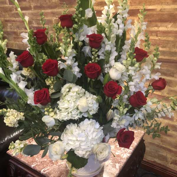 Red roses and white flowers arranged in a large vase