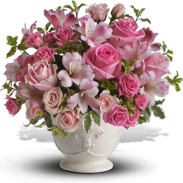 Pink roses and lilies arranged in a white vase