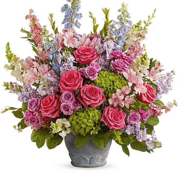 Mixed pink and lavender flowers arranged in a gray pot