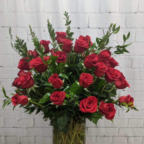 Red roses arranged in a clear glass vase