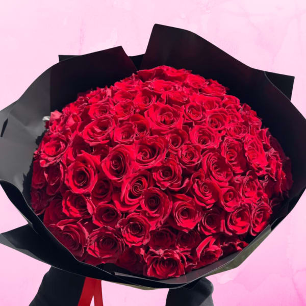 Large bouquet of red roses wrapped in black paper