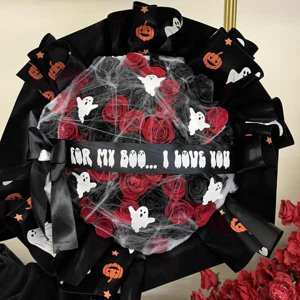 Halloween bouquet of red roses wrapped in black ribbon with ghost decorations