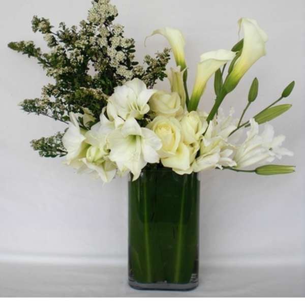 White flowers arranged in a green glass vase