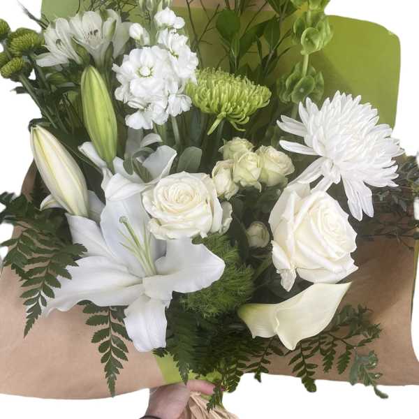 White bouquet with lilies, roses, and chrysanthemums wrapped in brown paper