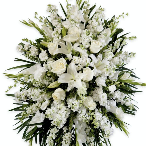 White floral standing spray with roses and lilies on an easel