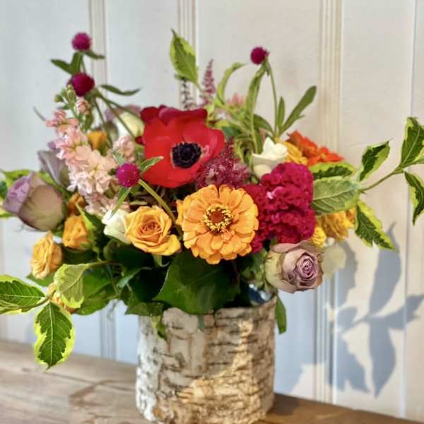 Colorful mixed flower arrangement in a birch bark vase
