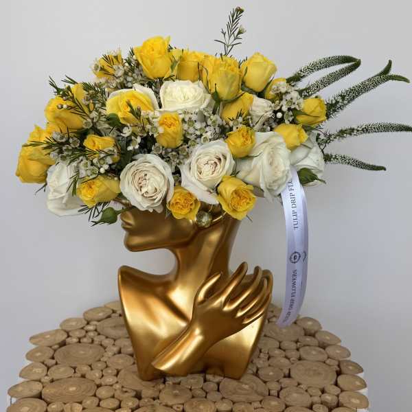 Yellow and white rose bouquet in a gold sculptural vase