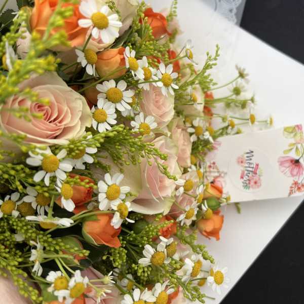 Bouquet of pale pink roses and white daisies with orange accents