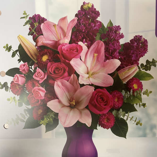 Pink lilies and roses in a purple vase
