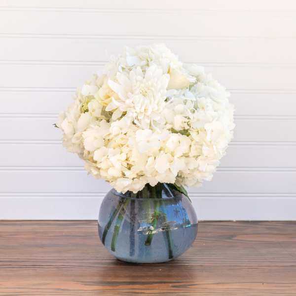 White flower bouquet in a blue glass vase