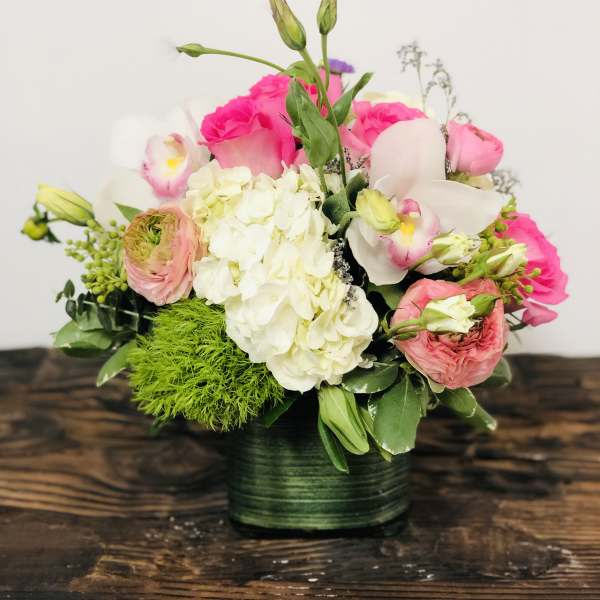 Pink and white floral arrangement in a green vase