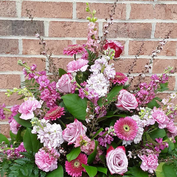 Large pink floral arrangement with roses, gerbera daisies, and carnations