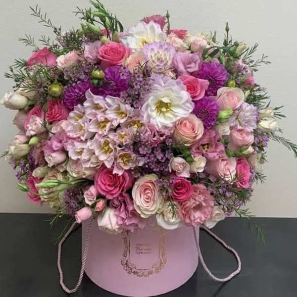 Pink and white mixed flower arrangement in a round pink box