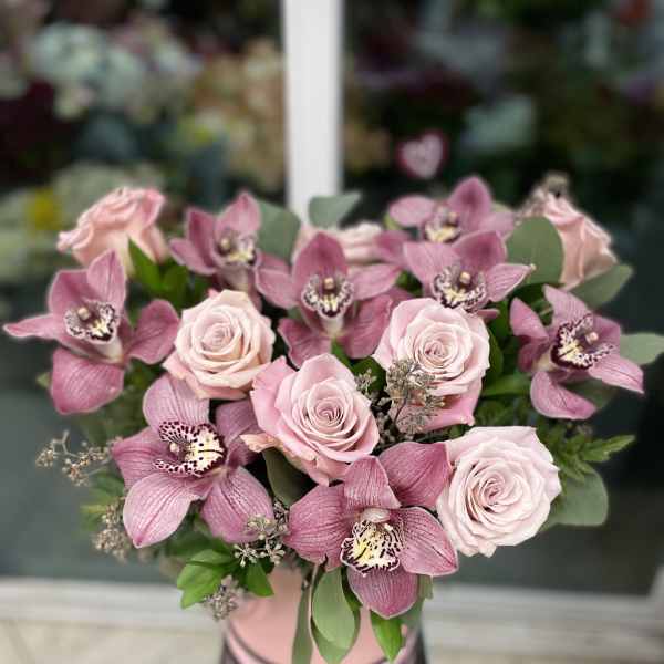 Pink roses and orchids arranged in a vase