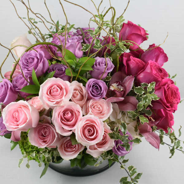 Pink and purple rose arrangement in a low vase