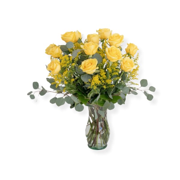 Yellow roses arranged in a clear glass vase with airy filler and eucalyptus