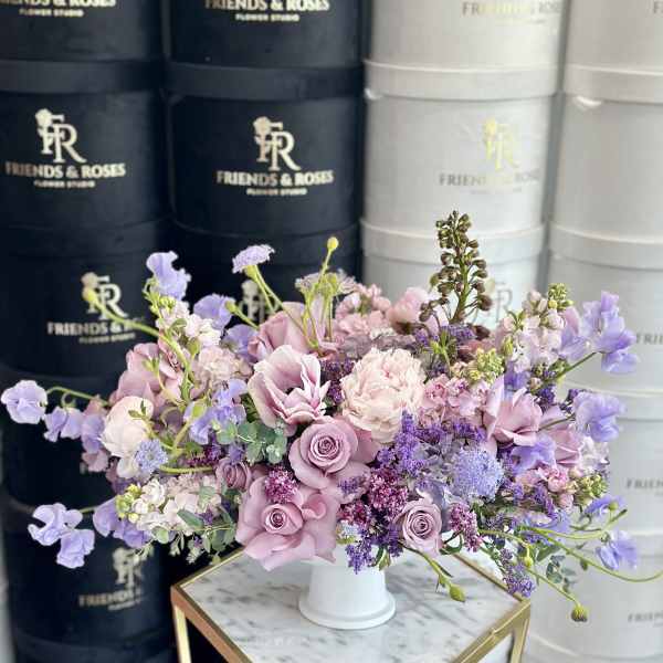 Lavender and pink floral arrangement in a white vase