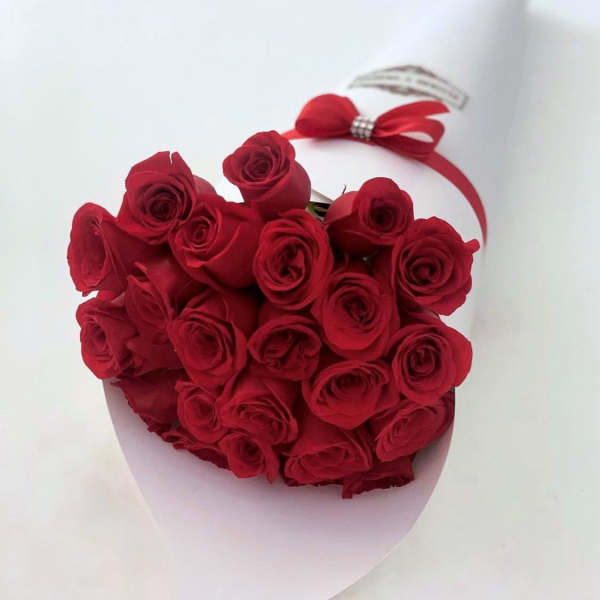 Heart-shaped bouquet of red roses with a red ribbon