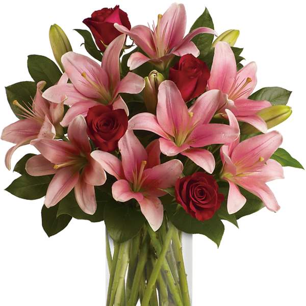 Pink lilies and red roses in a clear glass vase