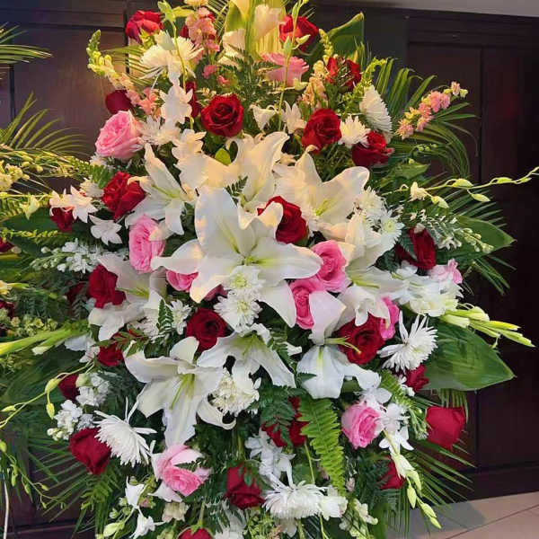 Large standing floral spray with white lilies, red and pink roses