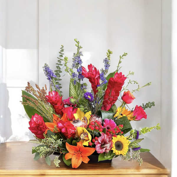 Bright mixed flower arrangement in a low black container