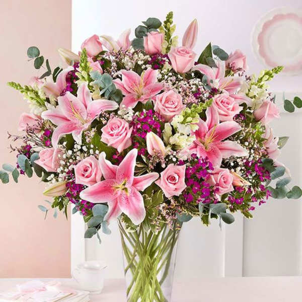 Pink lilies and roses in a clear glass vase