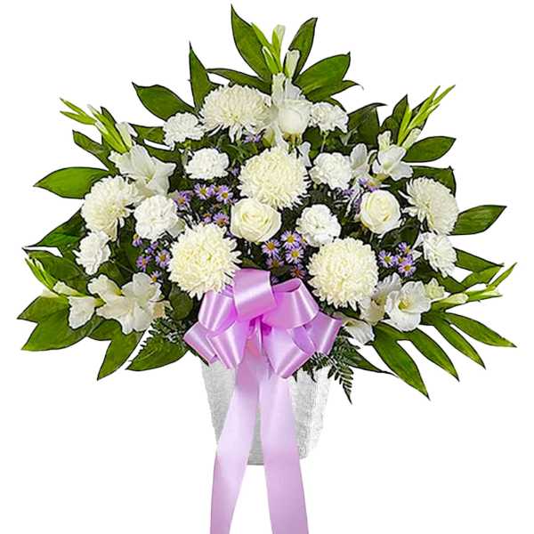 White floral arrangement with a pink ribbon in a vase