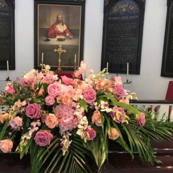 Large pink and peach floral casket spray with roses and orchids