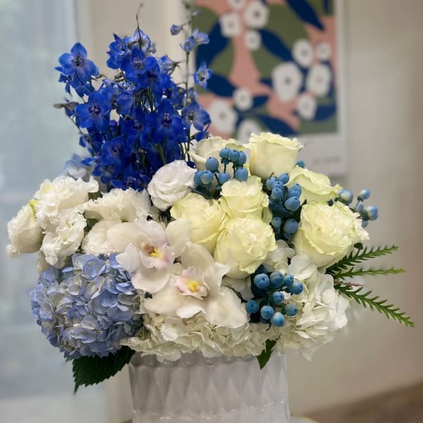 Blue and white floral arrangement in a white vase
