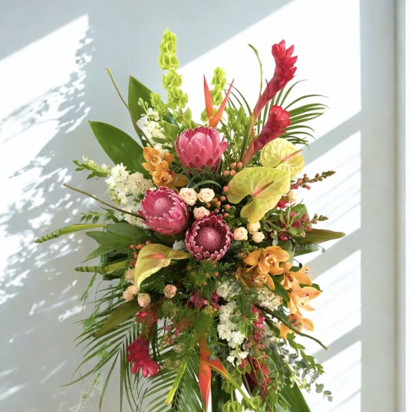 Tall tropical standing arrangement with pink and orange flowers