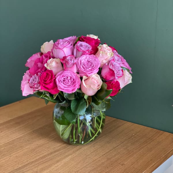 Pink and white roses arranged in a clear glass vase